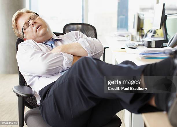 businessman sleeping with feet up at desk - feet up stock pictures, royalty-free photos & images