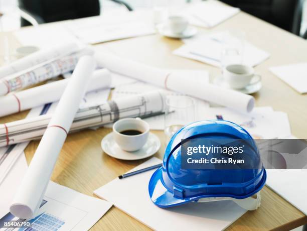 table with hard-hat and blueprints - work helmet stock pictures, royalty-free photos & images