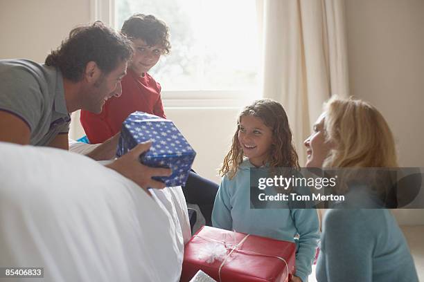 family opening christmas gifts - child giving gift stock pictures, royalty-free photos & images