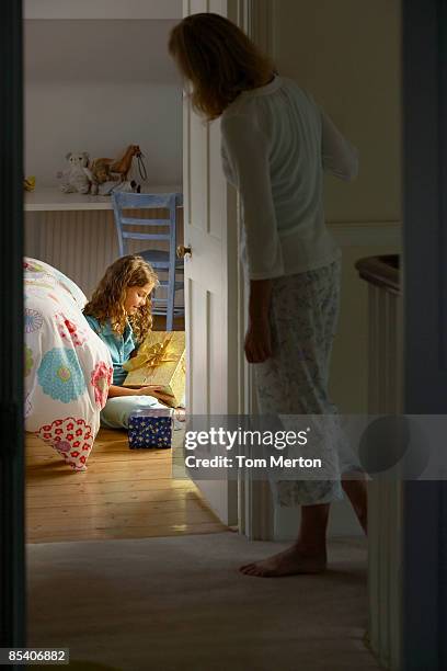 girl looking at christmas gift - kerst cadeau meisje stockfoto's en -beelden