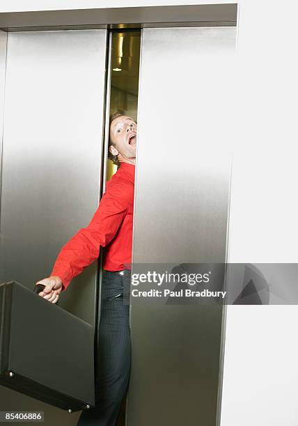 businessman getting stuck in elevators doors - hiss bildbanksfoton och bilder