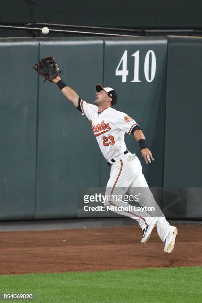 Joey Rickard of the Baltimore Orioles drives for a ball during a baseball game against the Boston Red Sox at Oriole Park at Camden Yards on September...