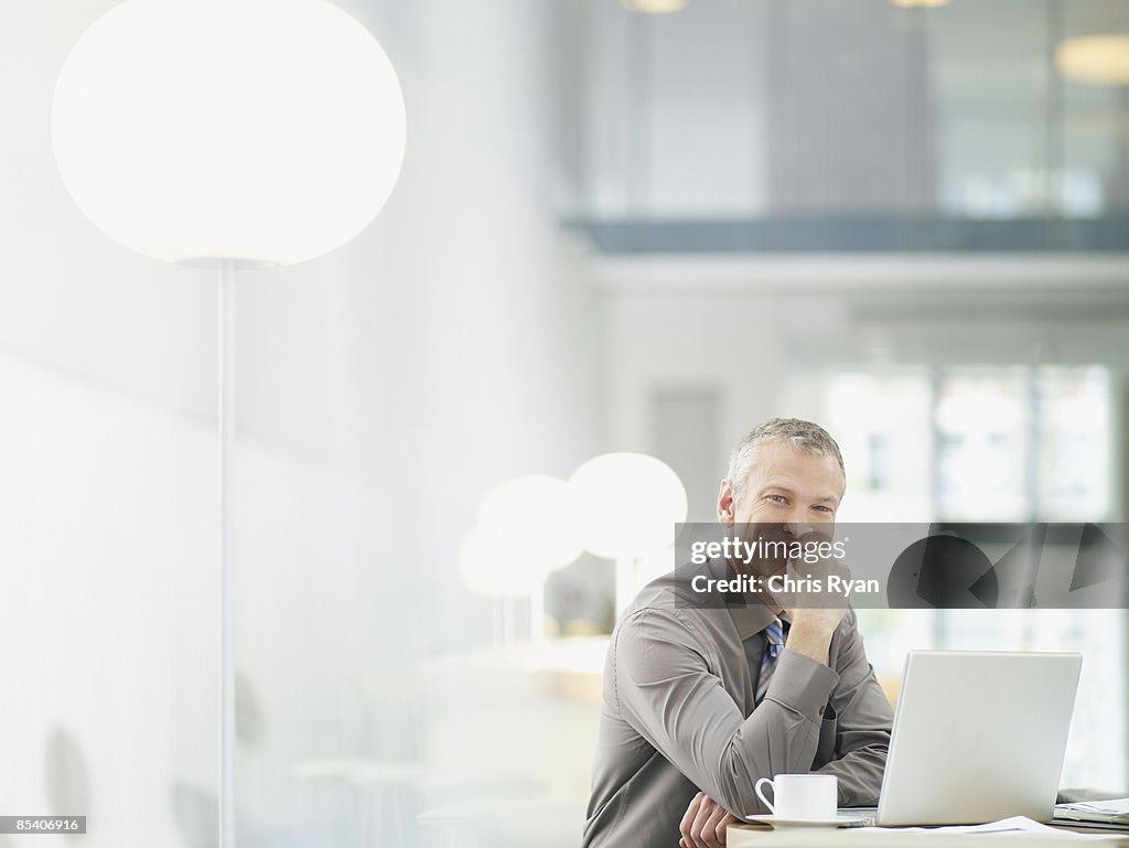 Empresário trabalhando no laptop em um café