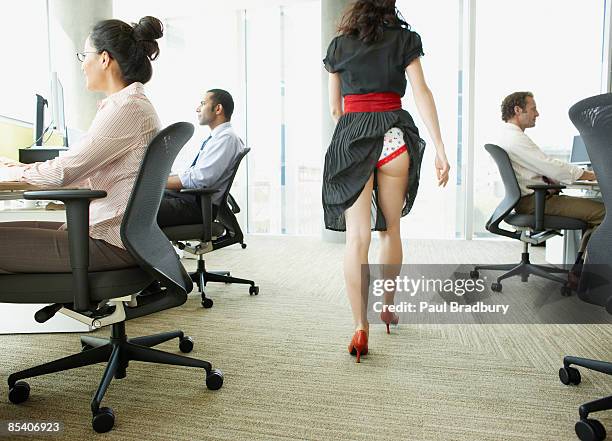 femme d'affaires avec la jupe pêchés dans les sous-vêtements - femme assise bureau photos et images de collection