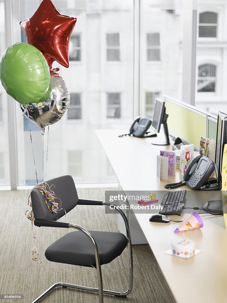 Birthday balloons tied to office chair