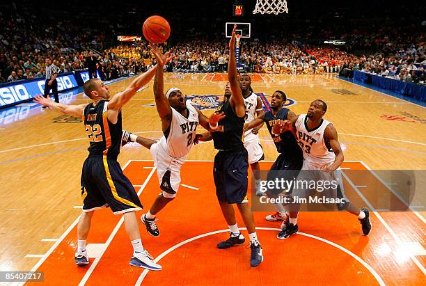 Levance Fields of the Pittsburgh Panthers drives to the hoop against Alex Ruoff and Da'Sean Butler of the West Virginia Mountaineers during the...