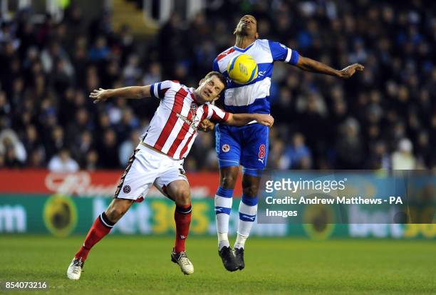 Sheffield United's Michael Doyle and Reading's Mikele Leigertwood battle for the ball during the FA Cup Fourth Round match at the Madejski Stadium,...