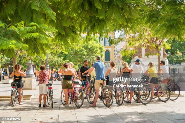 hören sie touristen, am plaza de la merced in malaga spanien zu führen - cycling tour de stock-fotos und bilder