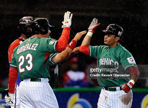 Oscar Robles of Mexico is congratulated at home plate by teammate Adrian Gonzalez after hitting a one-run home run against Cuba during the 2009 World...