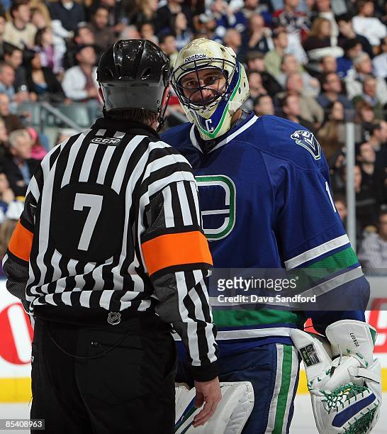 Roberto Luongo of the Vancouver Canucks speaks with referee Bill McCreary during the game against the Toronto Maple Leafs at Air Canada Centre on...