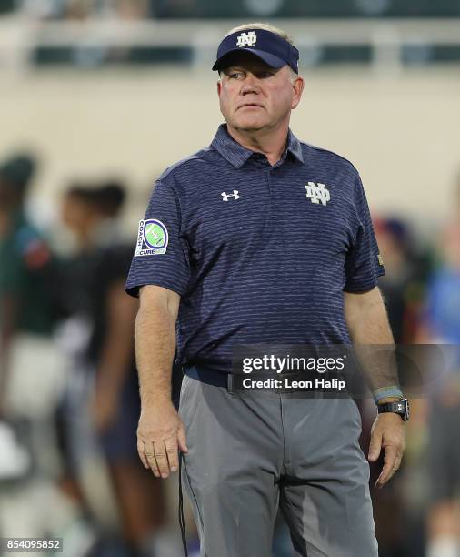 Notre Dame Fighting Irish head coach Brian Kelly watches the pregame warms ups prior to the start of the game against the Michigan State Spartans at...