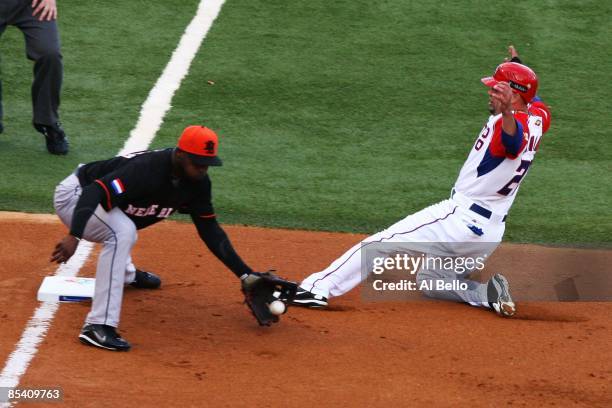Jesus Feliciano of Puerto Rico slides safely into third base as Yurendell DeCaster of The Netherlands is late with the tag during the 2009 World...