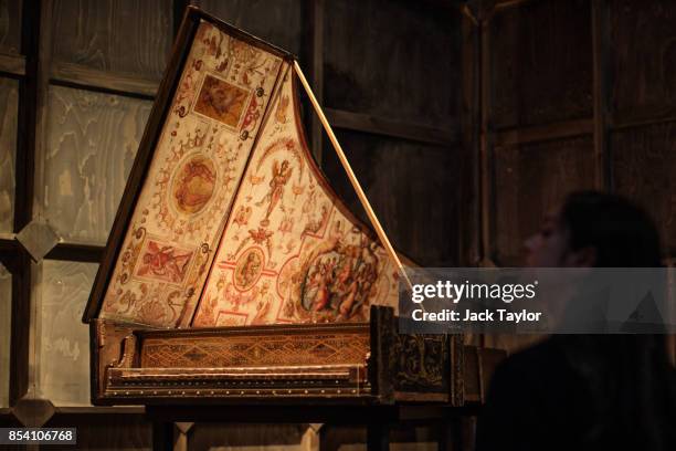 An employee stands beside a 1574 Harpsichord by Giovanni Baffo at the Victoria and Albert Museum during a photocall for their Opera: Passion, Power...