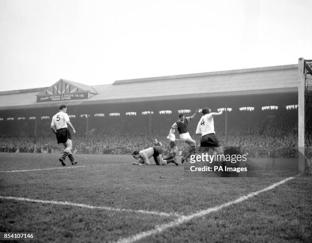 Young Fulham goalkeeper, Tony Macedo, shows his courage as he goes down to make a save, despite pressure from Burnley's inside-left, Jimmy Robson....