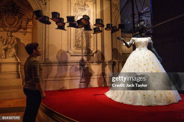 An employee looks at a dress for the character Violetta in La Traviata designed in 1994 by Bob Crowley at the Victoria and Albert Museum during a...
