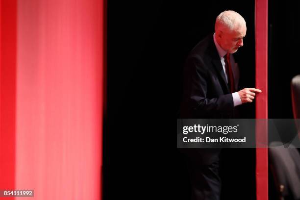 Labour Leader Jeremy Corbyn peers around boarding during speeches in the main hall, on day three of the annual Labour Party Conference on September...