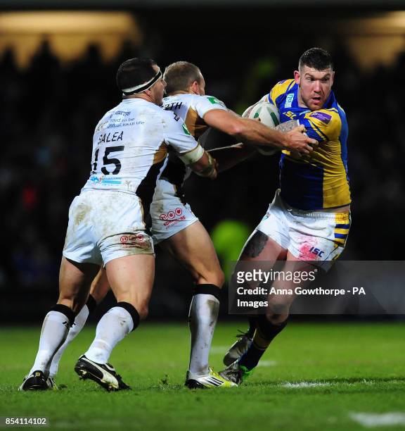 Leeds Rhinos' Brett Delaney is tackled by Hull FC's Ben Galea and Daniel Holdsworth during the Super League match at Headingley Carnegie Stadium,...