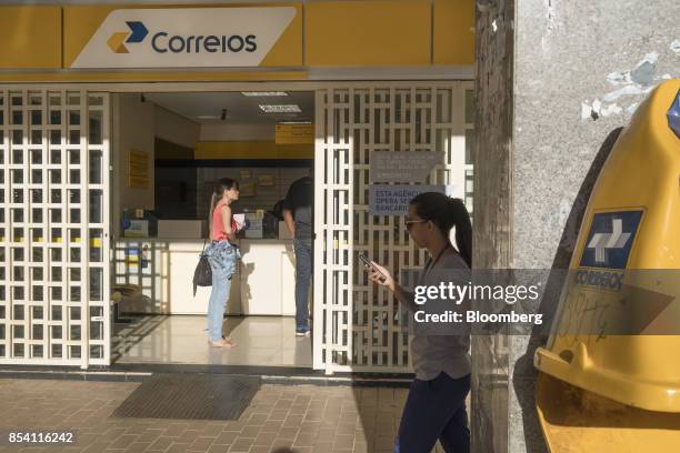 Pedestrian passes in front of a post office in Brasilia, Brazil, on Tuesday, Sept. 12, 2017. President Michel Temer is unwinding it all as he moves...