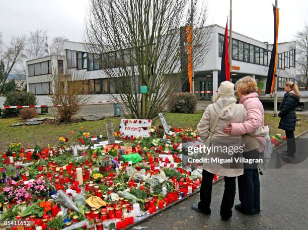 Candles and flowers are pictured in front of the Albertville School Centre on March 13, 2009 in Winnenden near Stuttgart, Germany. The poster reads...