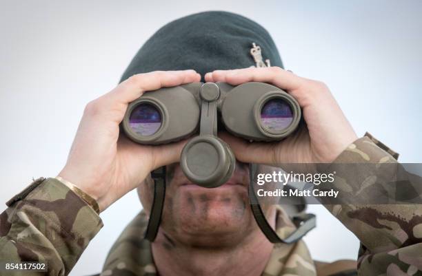 Soldier from 6 RIFLES looks through binoculars on the range at Okehampton Camp, Dartmoor, during the 6th Battalion, The Rifles' Annual Deployment...