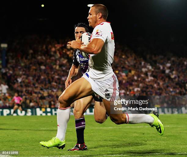 Matt Cooper of the Dragons races away from Cooper Cronk of the Storm on his way to scoring a try during the round one NRL match between the Melbourne...