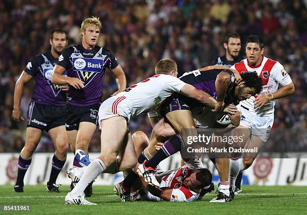 Greg Inglis of the Storm is tackled during the round one NRL match between the Melbourne Storm and the St George Illawarra Dragons at Olympic Park on...