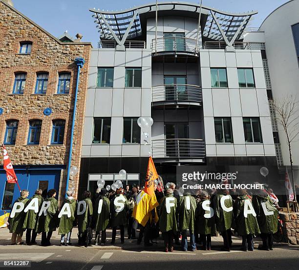 Around 20 people stage a demonstration calling for reforms on tax havens on March 13, 2009 in St Helier, on the British island of Jersey. The protest...