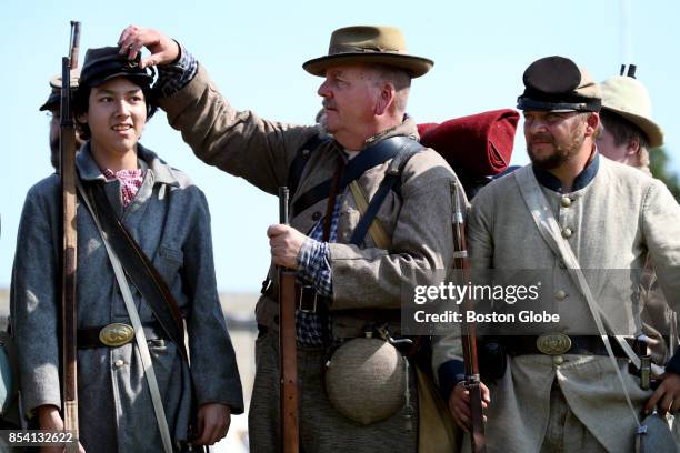 Pete Northrup, center, helps a young reenactor with is cap during the Civil War Living History Reenactment at Historic Fort Adams in Newport, RI on...