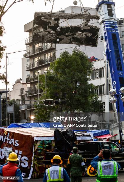 Large piece of wall is removed with a crane from the rubble of a building toppled by a magnitude 7.1 quake that struck central Mexico a week ago, in...