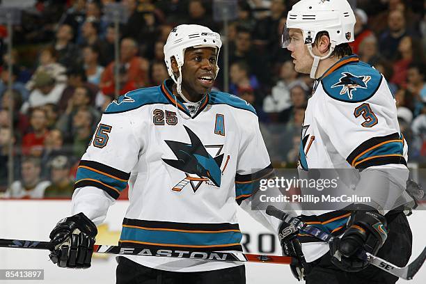 Mike Grier and Douglas Murray of the San Jose Sharks stand on the ice against the Ottawa Senators during the game on February 26, 2009 at the...