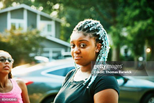 Portrait of teenage girl hanging out with neighborhood friends on summer evening