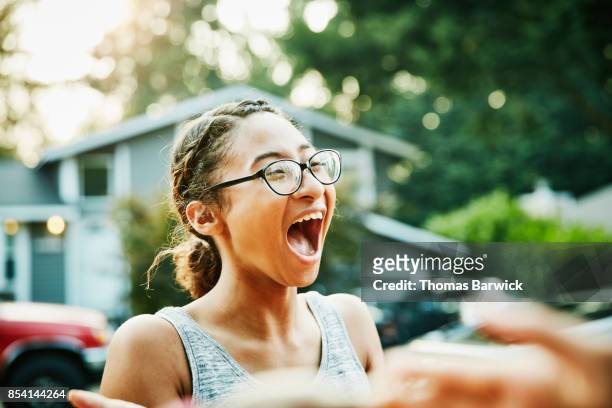 laughing young woman hanging out with neighborhood friends on summer evening - funny black girl stock-fotos und bilder