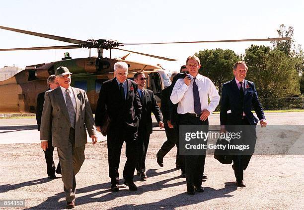 British Prime Minister Tony Blair, second from right, is escorted by unidentified official and security personnel as he walks towards his car...