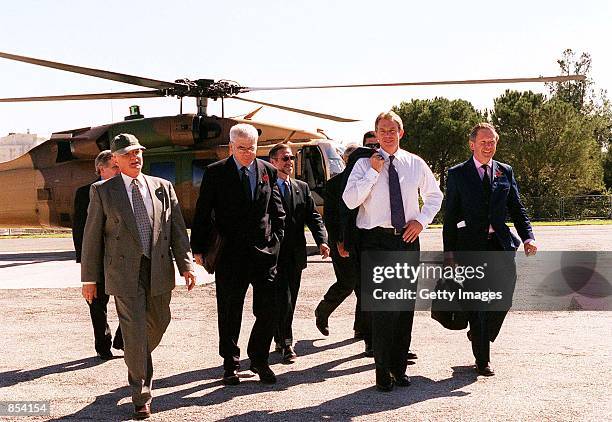 British Prime Minister Tony Blair, second from right, is escorted by unidentified official and security personnel as he walks towards his car...