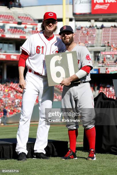 Pedroia of the Boston Red Sox presents Bronson Arroyo of the Cincinnati Reds with the number 61 from the scoreboard at Fenway Park during a ceremony...