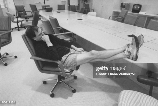 Apple Computer head Steve Jobs deep in thought, propping sneakered feet on conference table in boardroom at Apple HQ day before heading to Boston for...