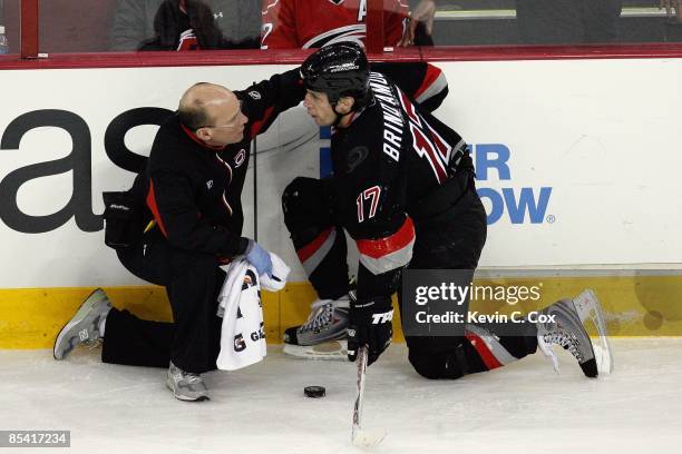 Head athletic trainer Peter Friesen of the Carolina Hurricanes attends to Rod Brind'Amour during the game against the Buffalo Sabres on February 26,...