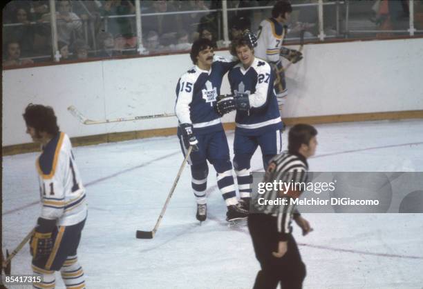 Darryl Sittler and Denis Dupere of the Toronto Maple Leafs celebrate on the ice during an NHL game against the Buffalo Sabres circa 1973 at the...