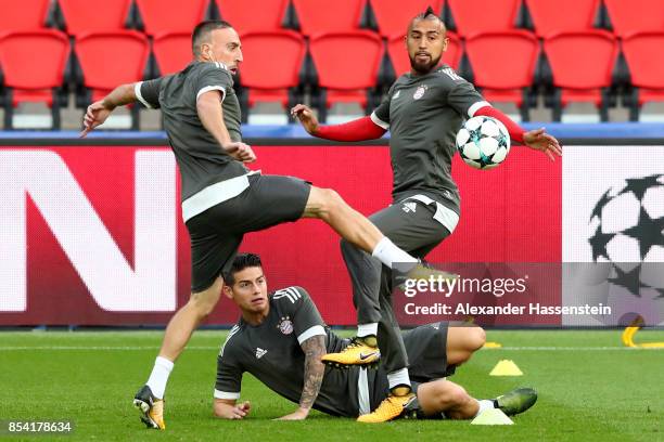 Franck Ribery of Bayern Muenchen battles for the ball with his team mates James Rodriquez and Arturo Vidal during a training session ahead of the...