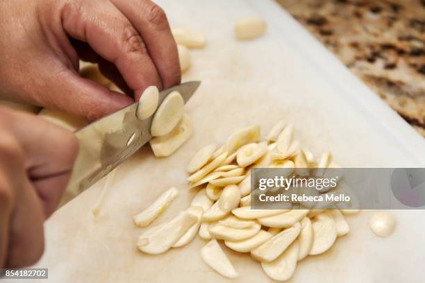 slicing garlic on close-up - garlic foto e immagini stock