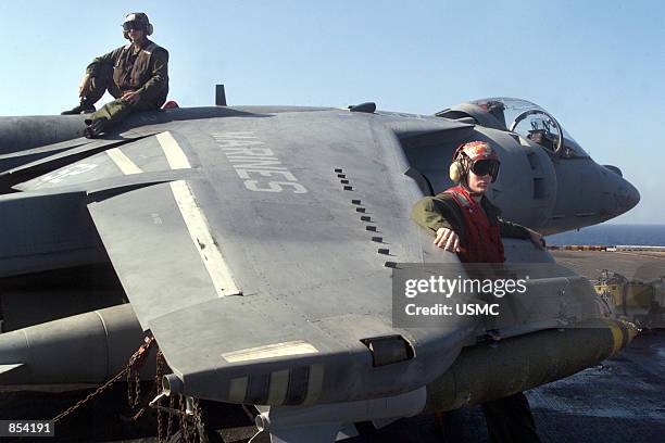 Marines rest onboard the USS Peleliu after preparing an AV-8B "Harrier" for a mission over Afghanistan November 2, 2001 in support of Operation...