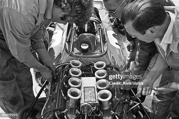 Mechanics work on a Cosworth Ford engine in Graham Hill's Brabham BT33 at the Questor Grand Prix in which Formula One cars competed with Formula A...