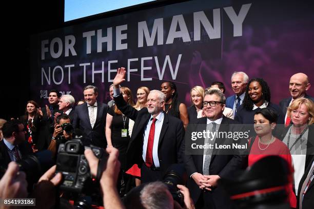 Labour party leader Jeremy Corbyn waves to delegates in the main hall as Deputy Labour party leader Tom Watson and Shadow Attorney General Shami...