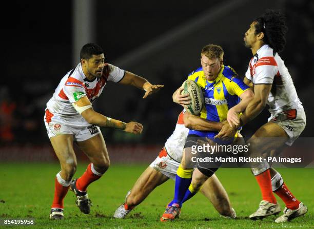 Warrington Wolves' Chris Riley is tackled by St Helens Willie Manu Mark Flanagan and Sia Soliola during the Super League match at Halliwell Jones...