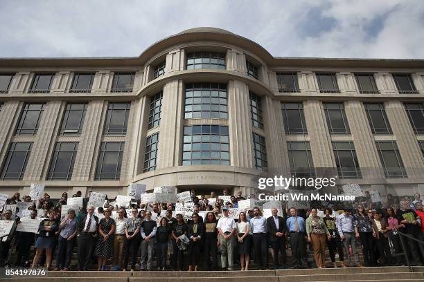 Protesters and members of the Georgetown University faculty stand on the steps of the Georgetown University Law Center before U.S. Attorney General...