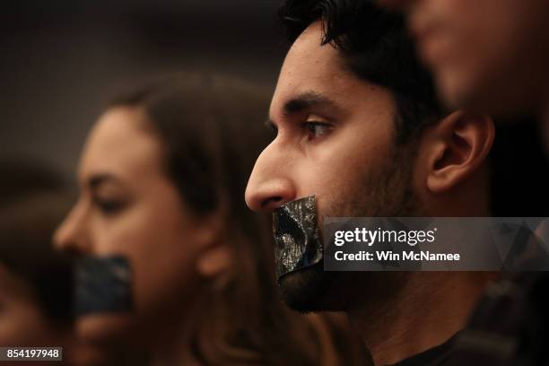 Georgetown University Law School students cover their mouths with tape as U.S. Attorney General Jeff Sessions speaks at the Georgetown University Law...