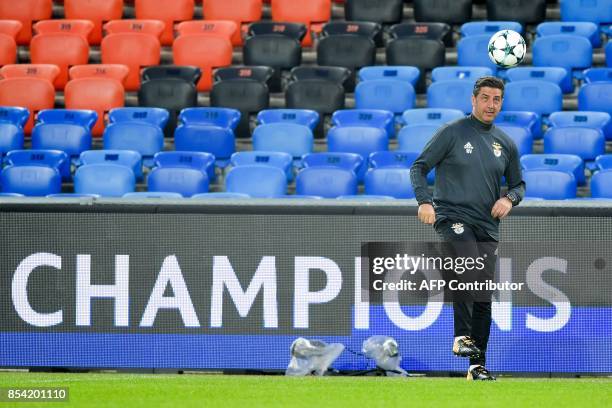 Benfica's coach Rui Vitoria plays with a ball during a training session on the eve of the UEFA Champions league Group A football match between FC...