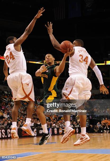 Guard Curtis Jerrells of the Baylor Bears goes up for a shot against Justin Mason and Dexter Pittman of the Texas Longhorns during the Phillips 66...