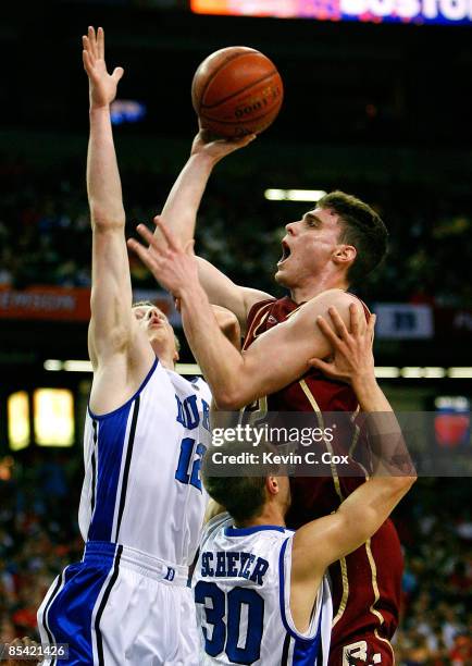 Joe Trapani of the Boston College Eagles shoots over Kyle Singler and Jon Scheyer of the Duke Blue Devils during day two of the 2009 ACC Men's...