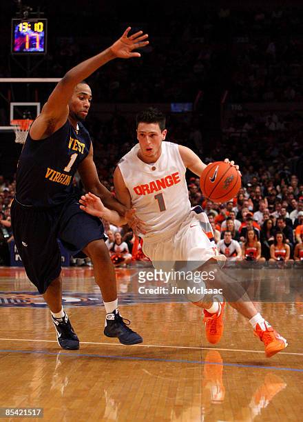 Andy Rautins of the Syracuse Orange handles the ball against Da'Sean Butler of the West Virginia Mountaineers during the semifinal round of the Big...